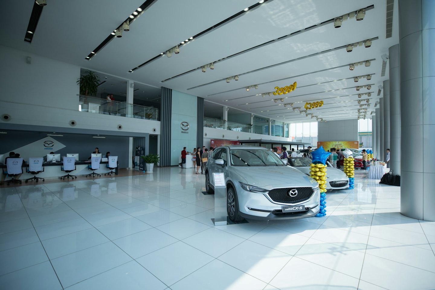 Nové strieborné autá značky Mazda vystavené v jasnom showroome predajcu.
